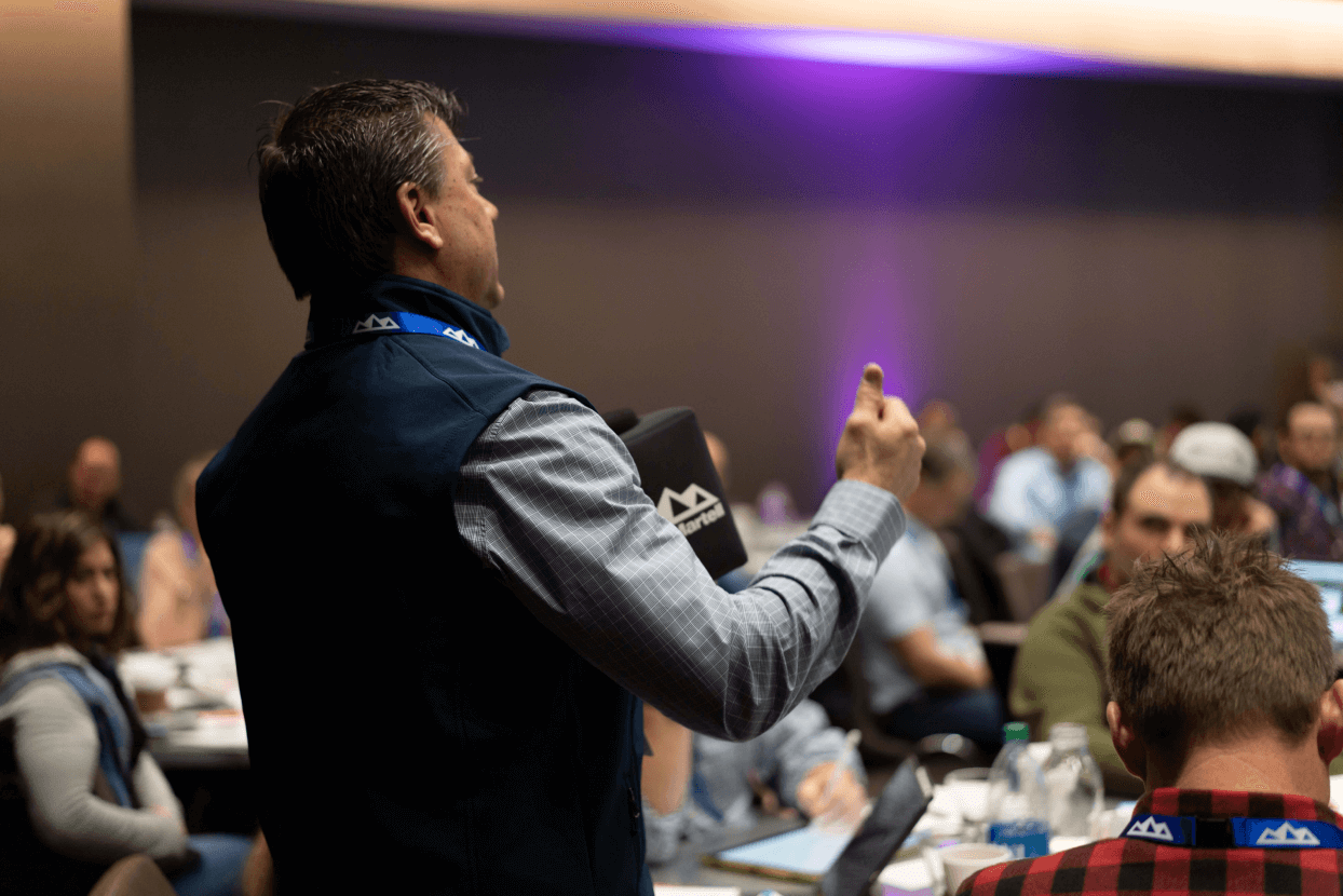 A man speaks in front of a full conference room